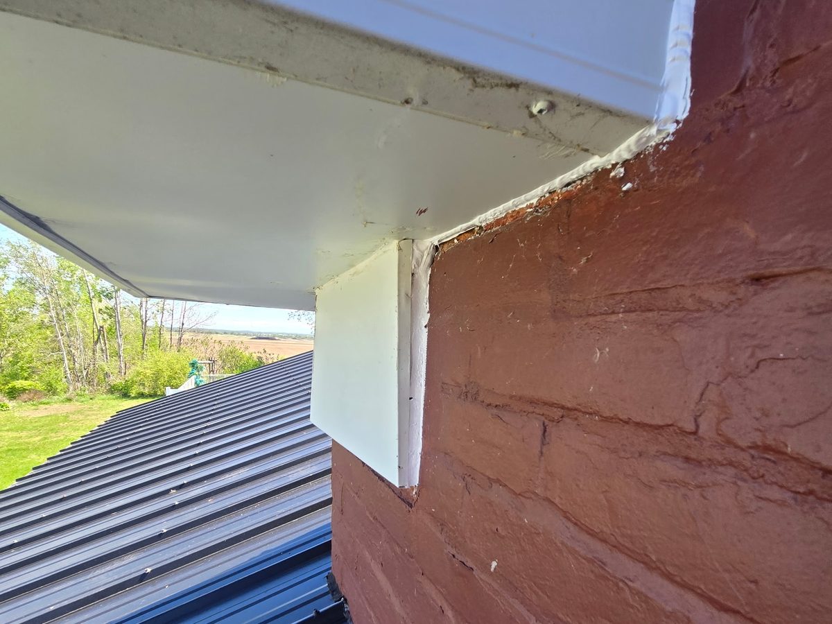 A sealed gap where the soffit meets the brick